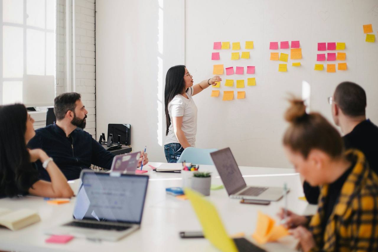 A team mapping a workflow across a wall of notes in a meeting room